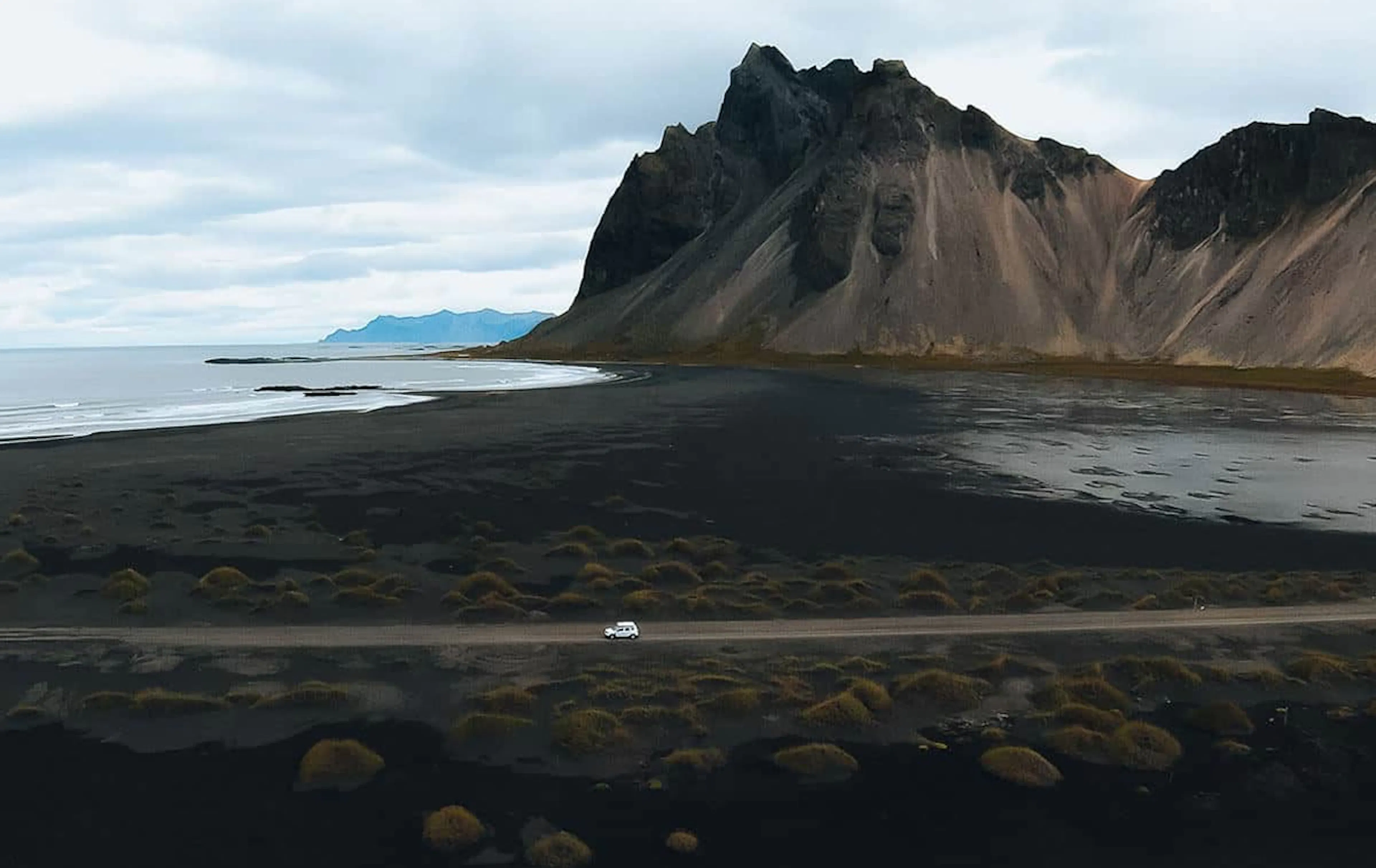 Aerial view of a white car on a mountain road in Iceland