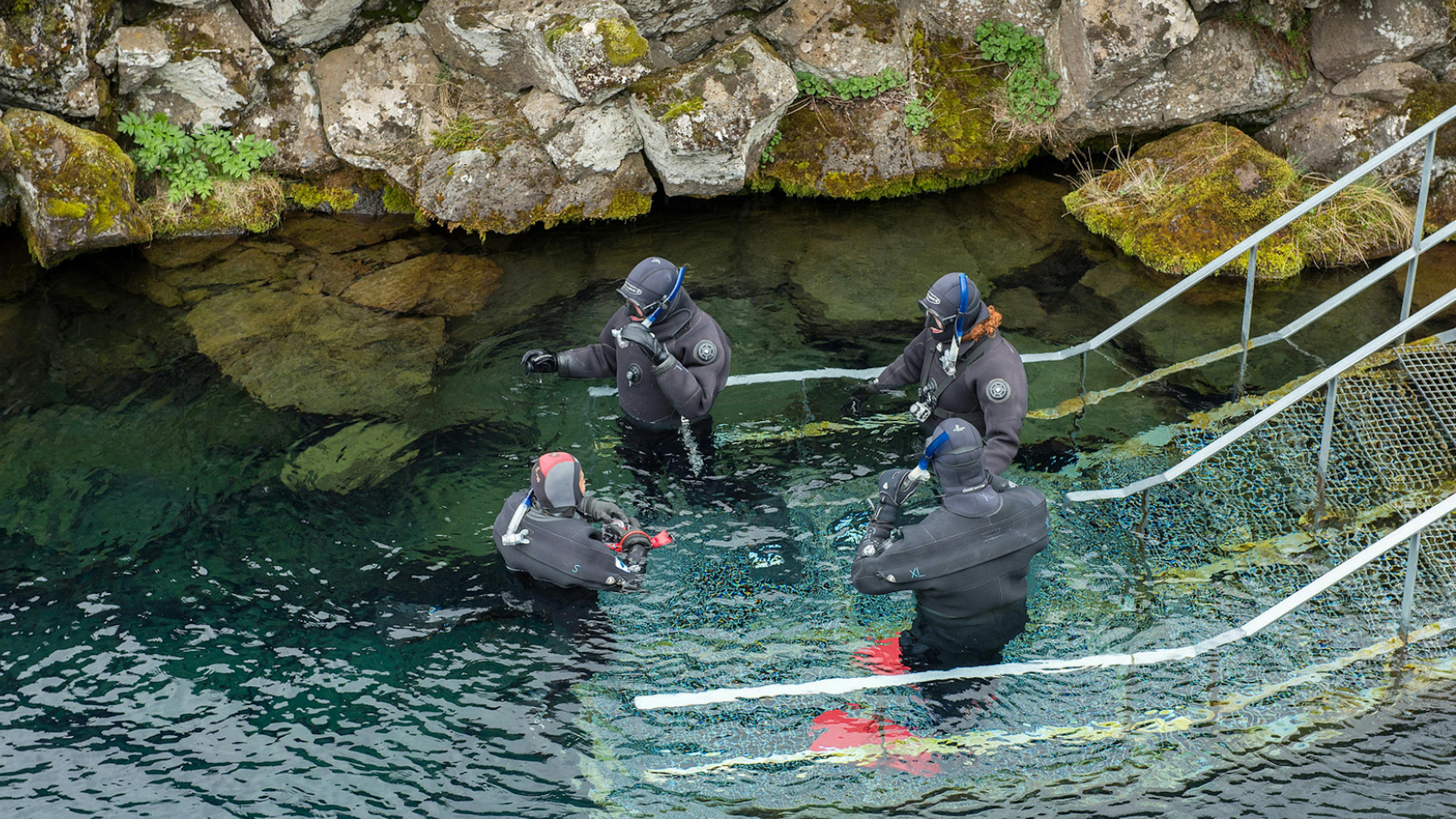 People in dry suits preparing to dive at Silfra Fissure.