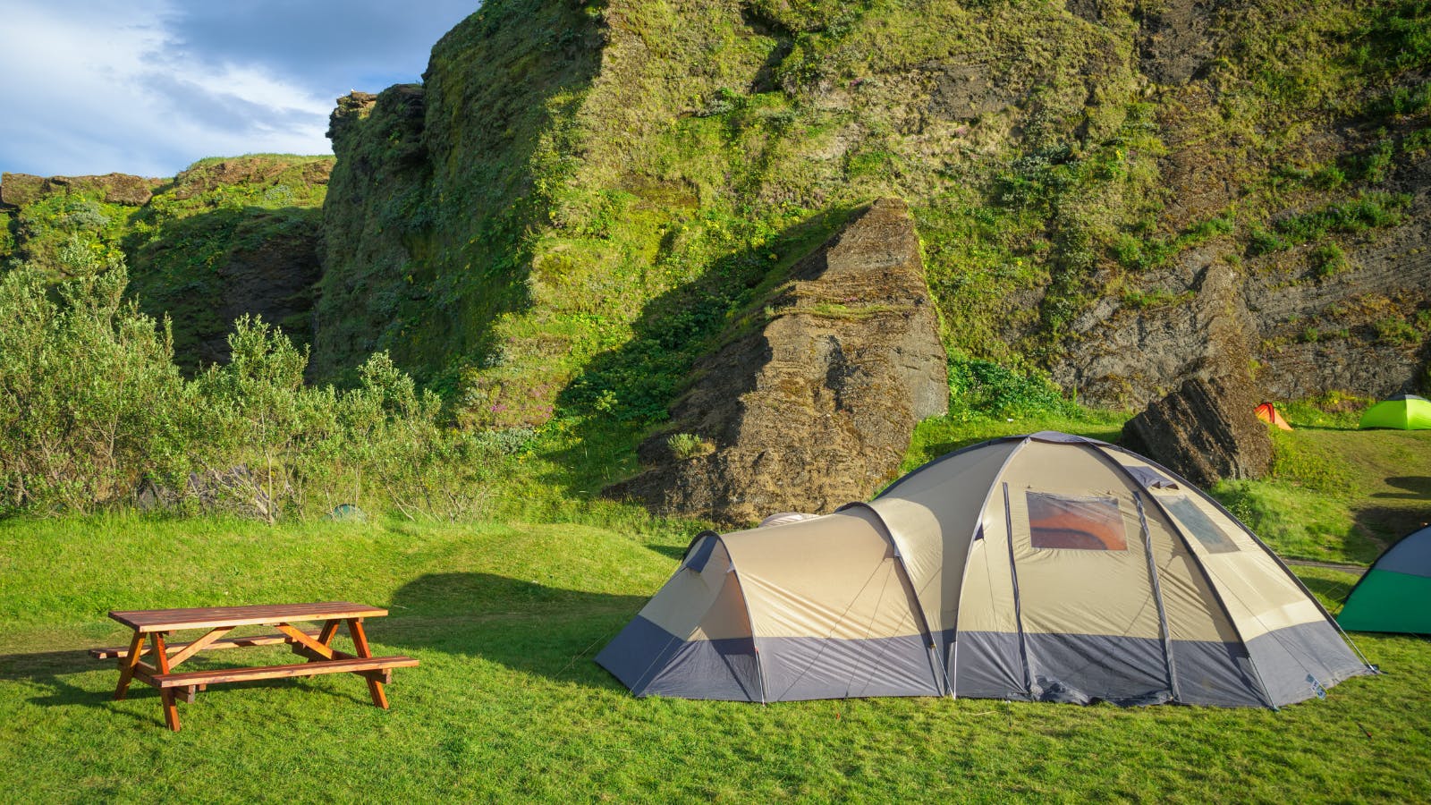 Dome tent next to picnic bench at campsite in Iceland.