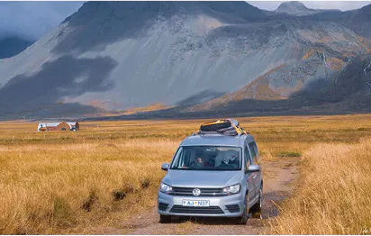 VW camper driving on a mountain road in Iceland
