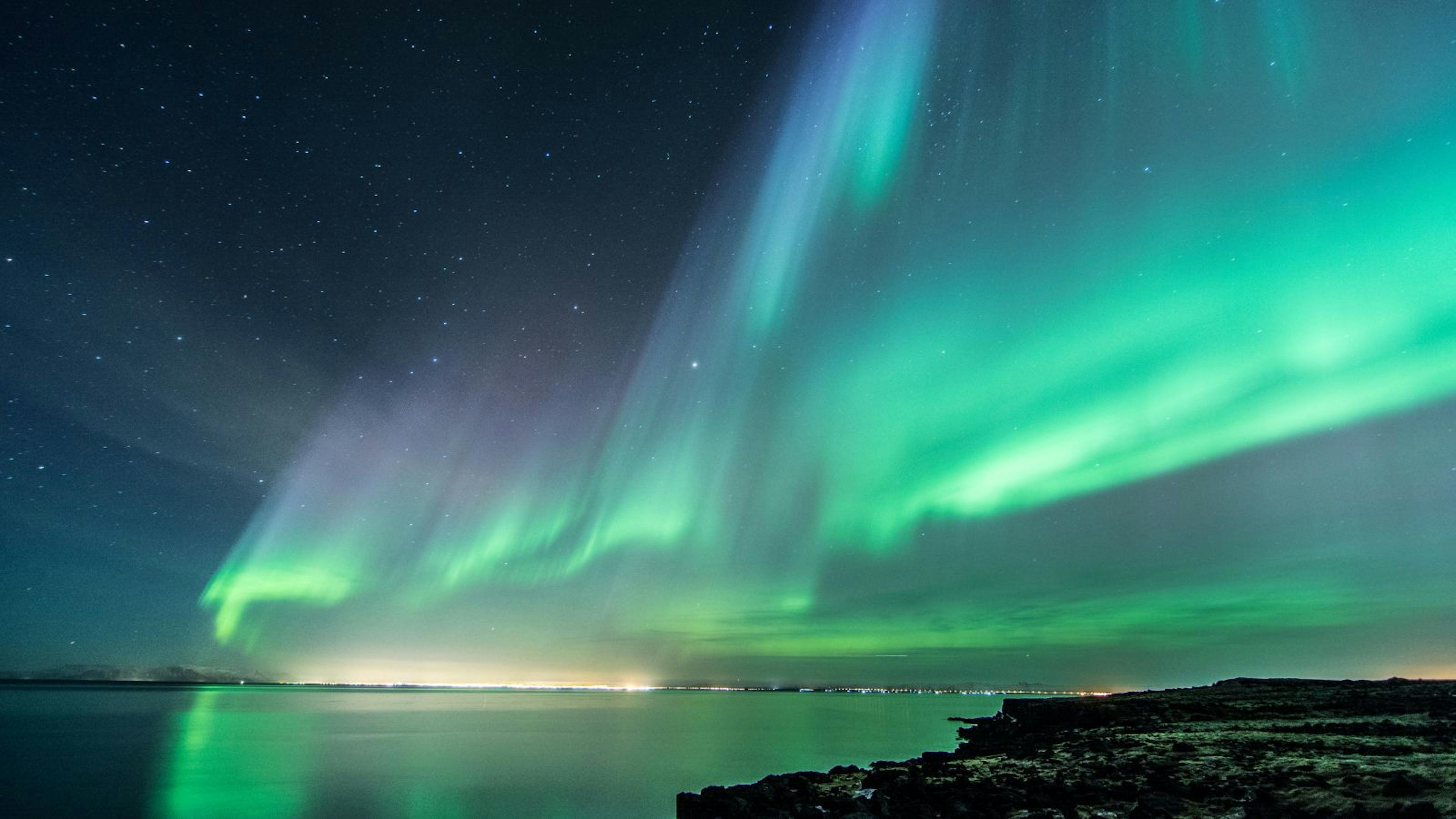 Northern Lights above a body of water in Iceland.
