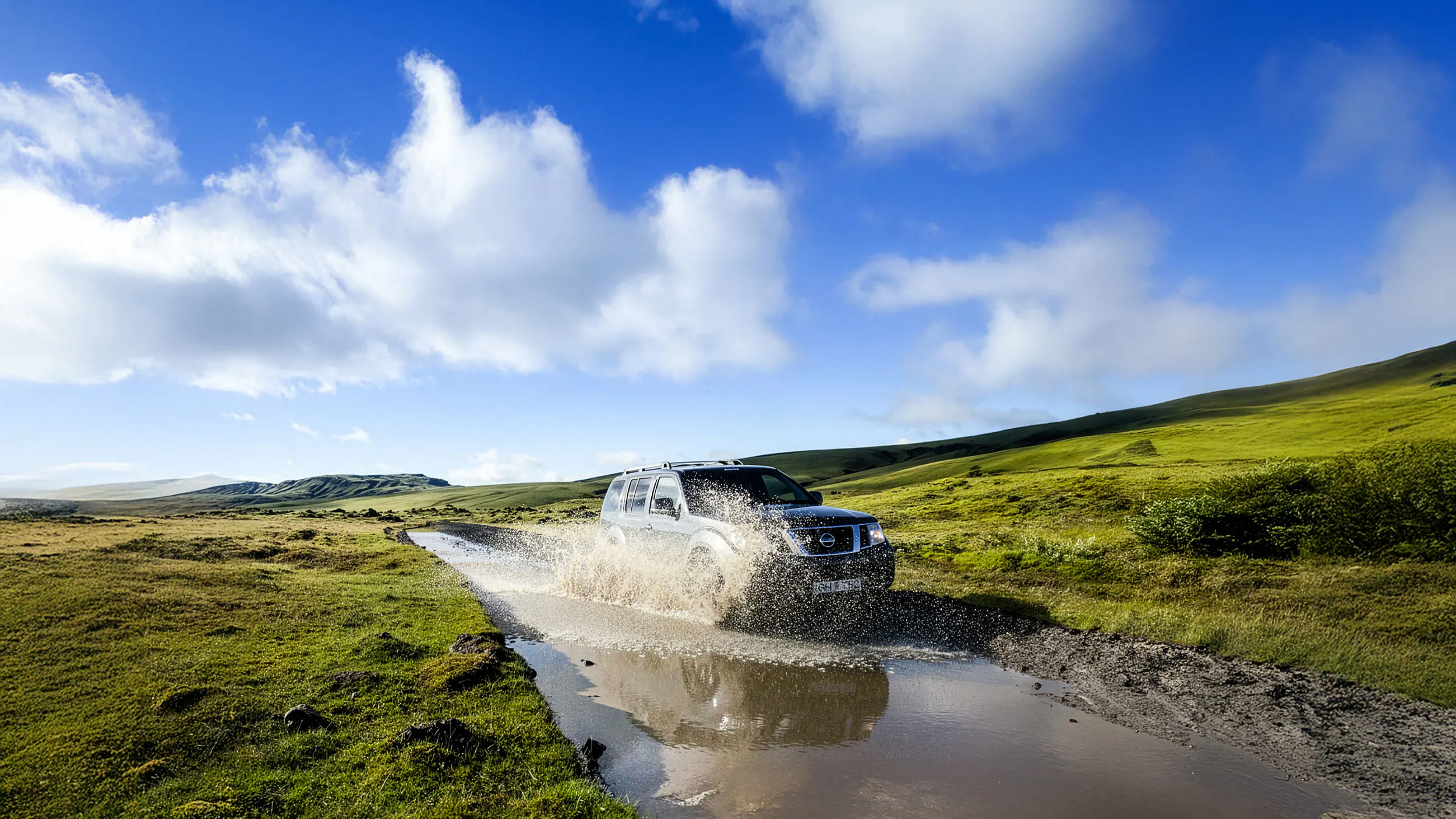 4x4 vehicle splashing through a river in Iceland
