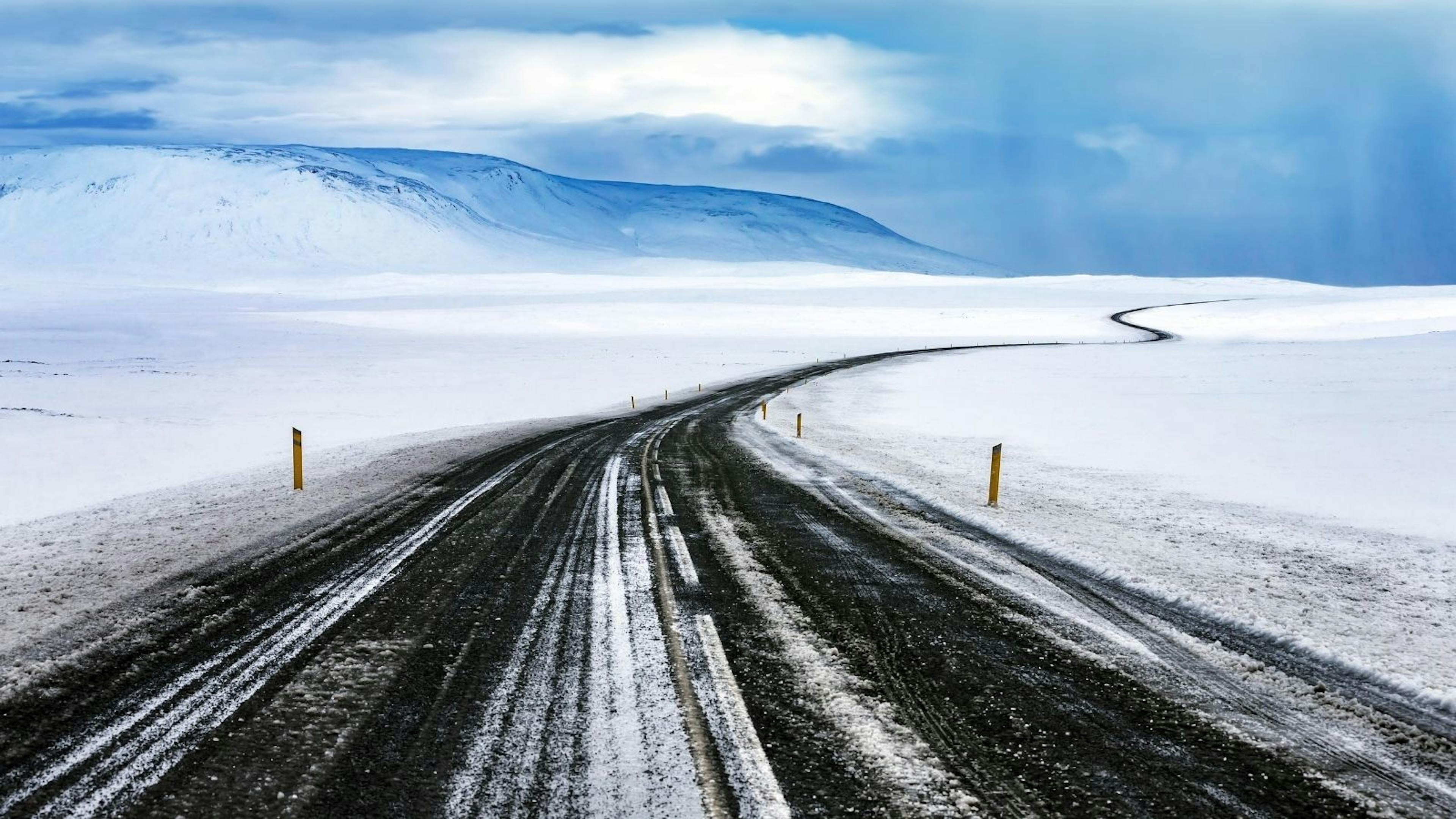 An isolated snowy winter road in Iceland.


