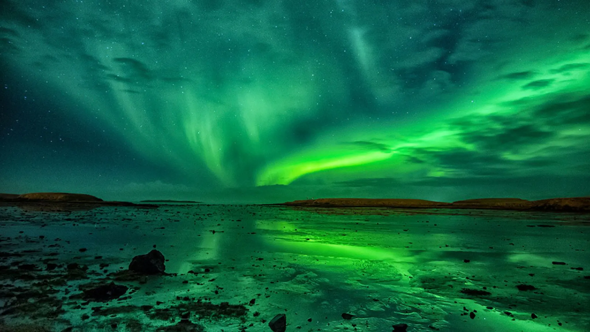 Northern Lights in Iceland over a frozen body of water.