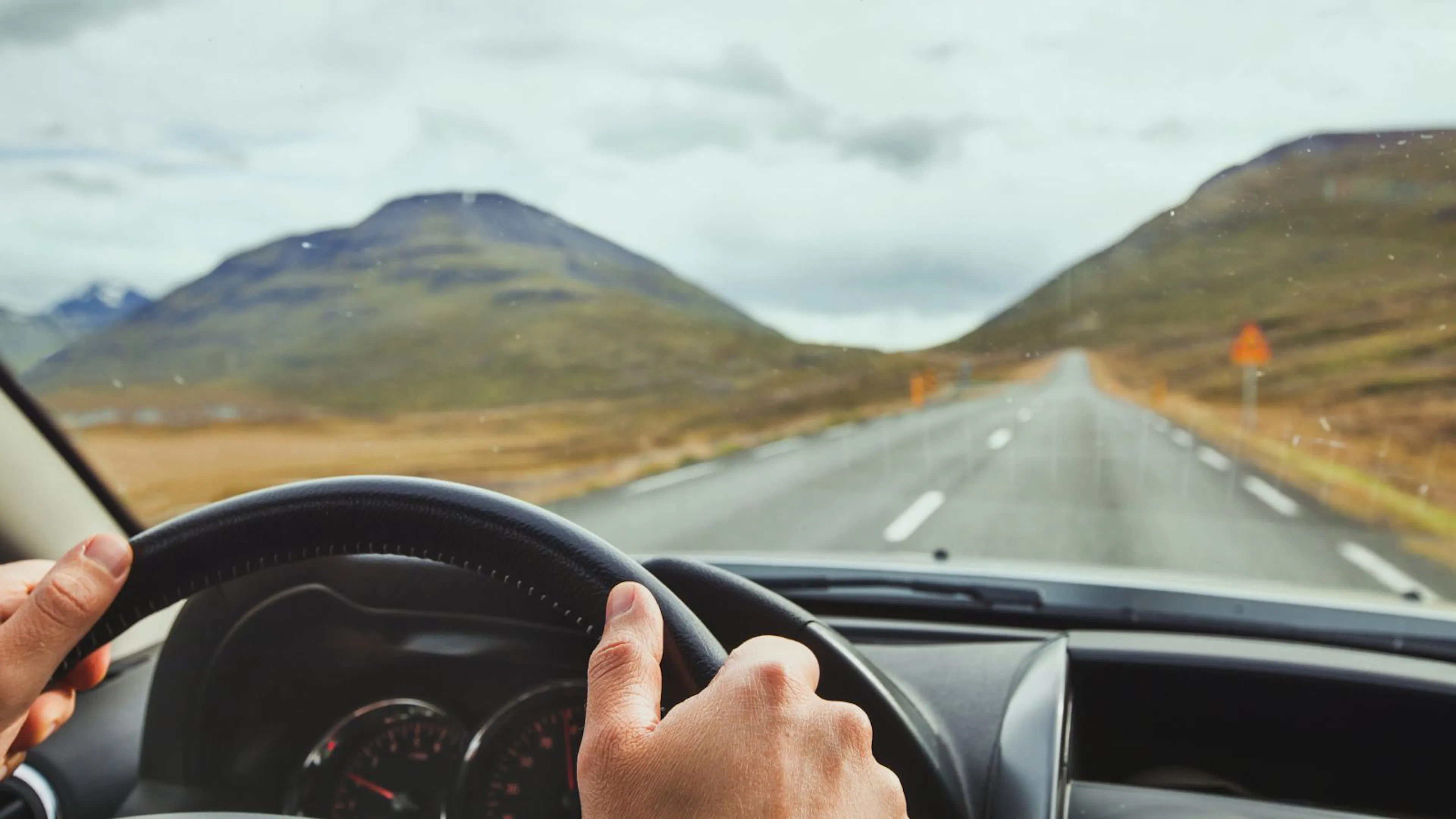View out the windscreen of a person driving on Icelandic roads.
