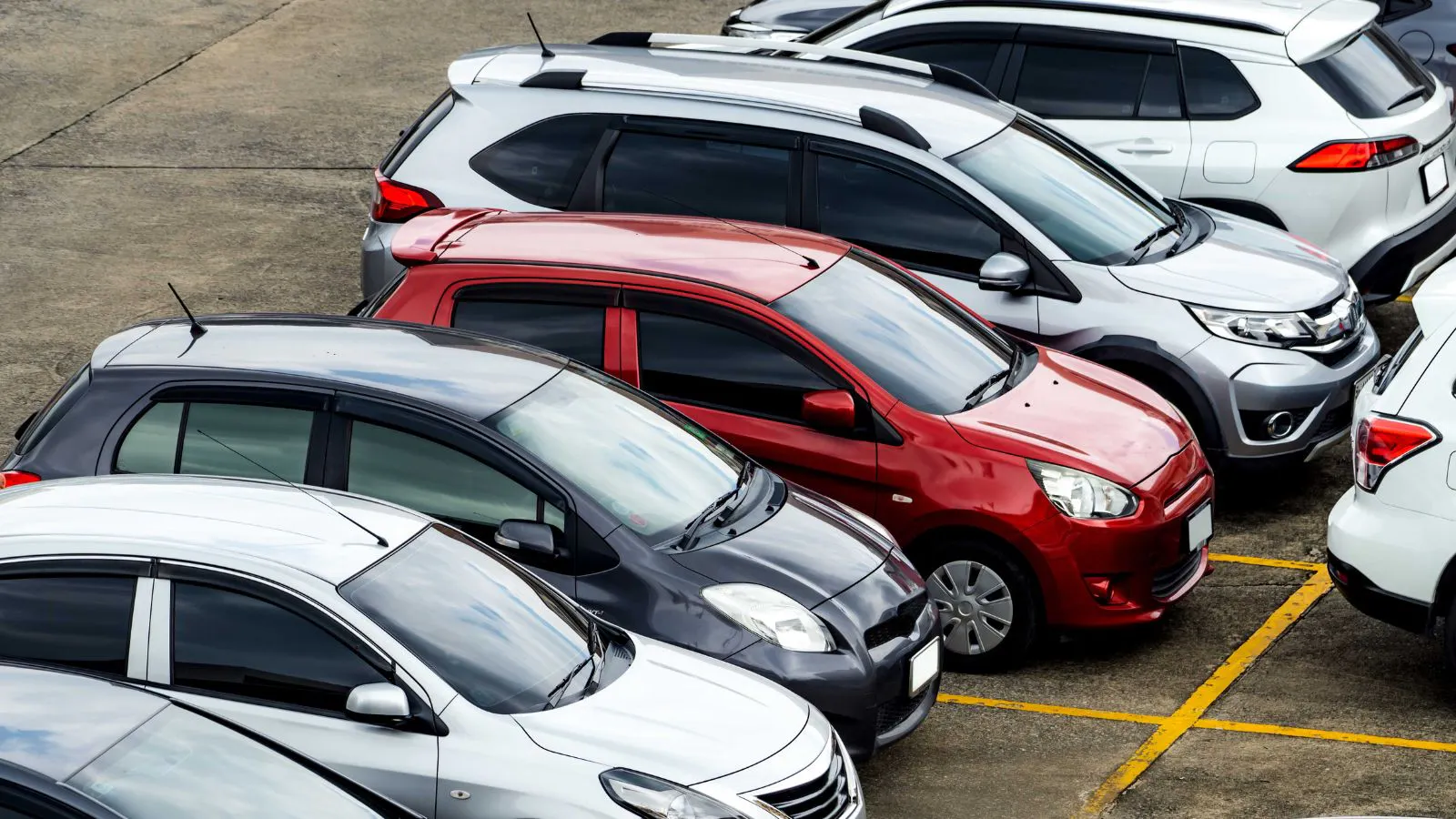 Rental cars parked at a rental lot at an airport.