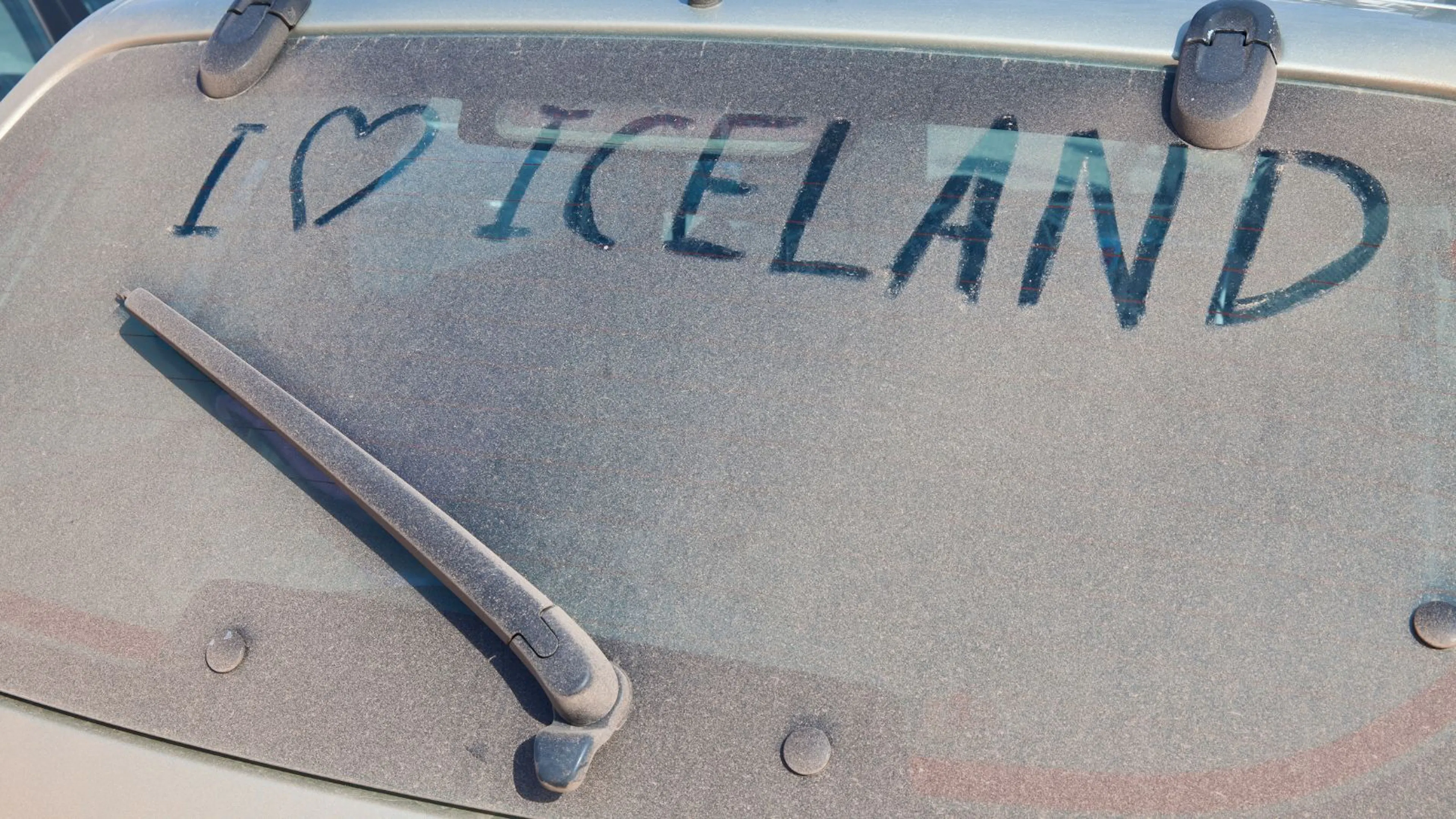 Dirty car window with I heart Iceland written in the dust.
