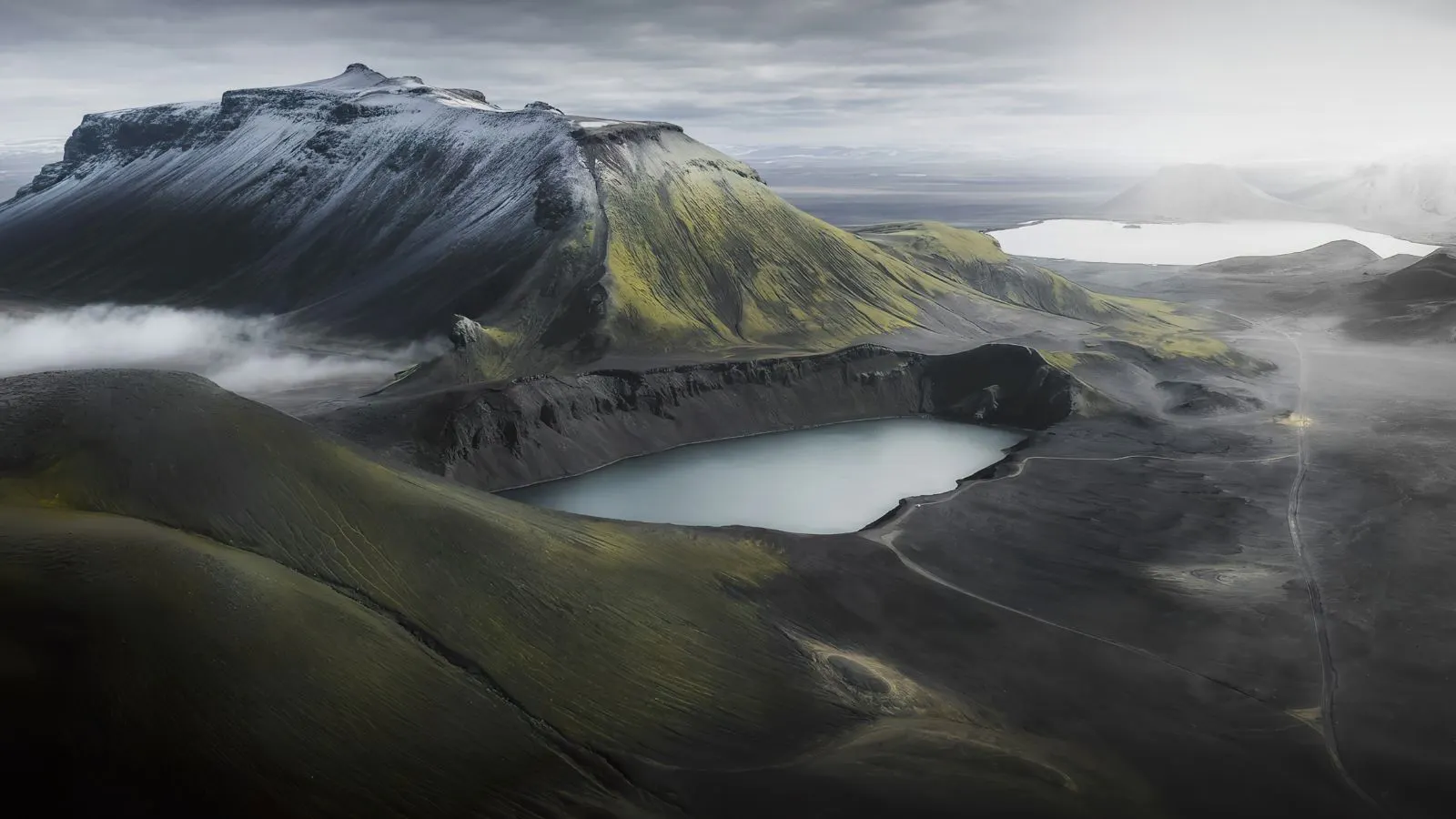 A lake by a mountain in the Icelandic Highlands on a misty morning.