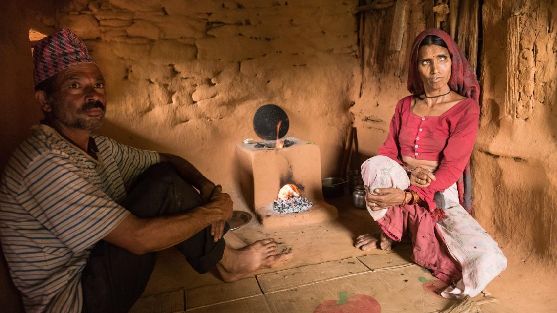 Two people next to a cookstove.