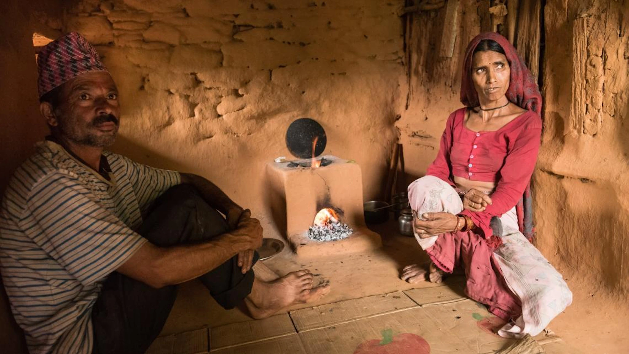 Two people next to a cookstove.