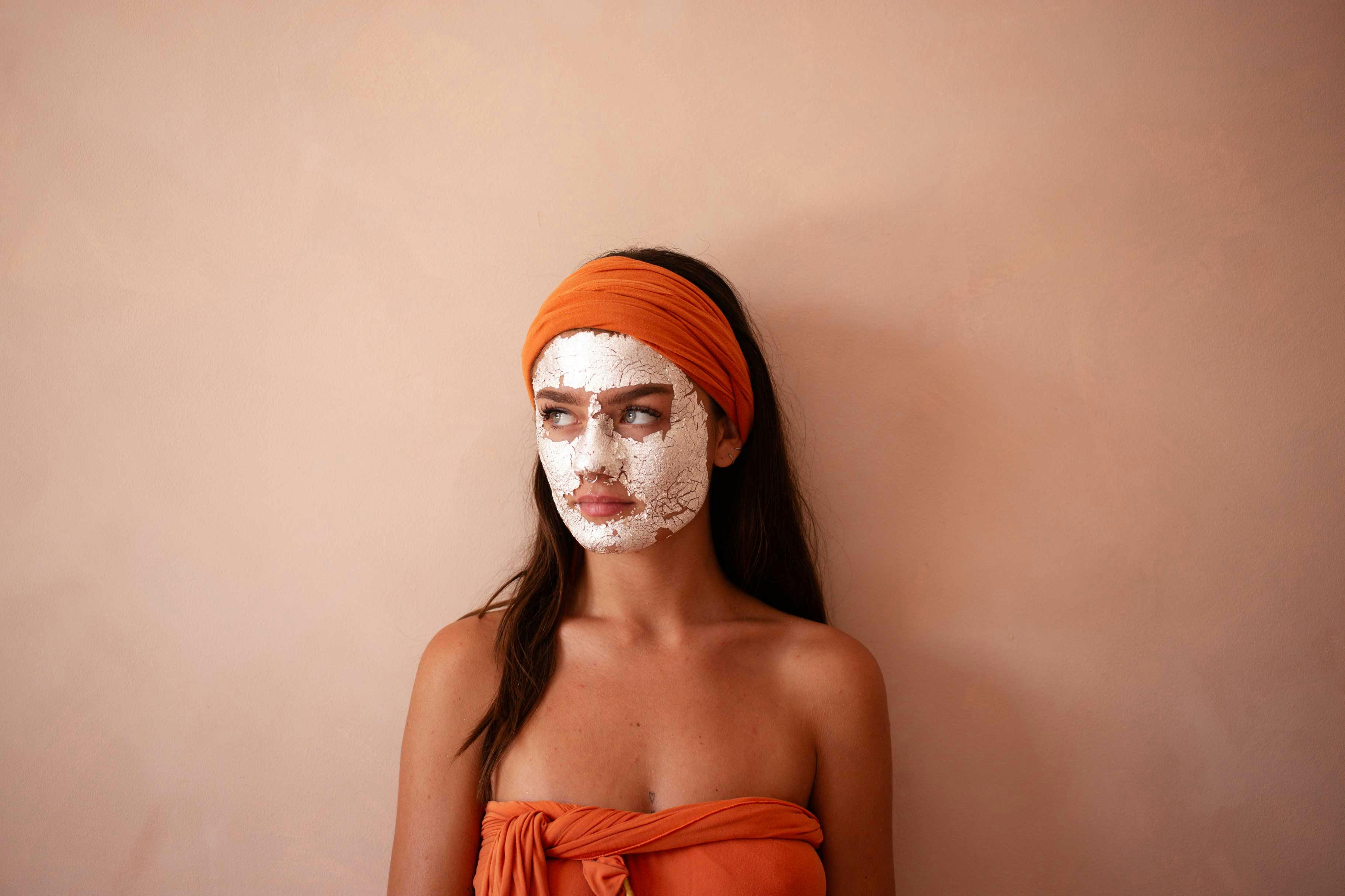 Woman with a 24k Silver mask applied, relaxing in a serene spa setting.