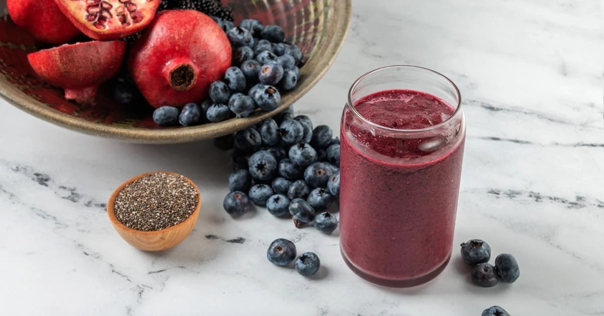 mixed berry smoothie with surrounding fruit ingredients