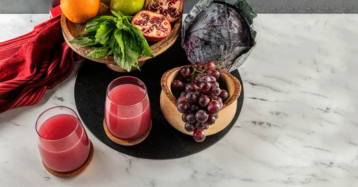 two glasses of pomegranate juice on a marble table