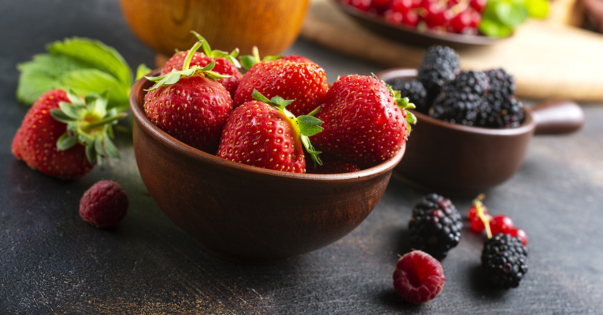 strawberries and blackberries in wooden bowls