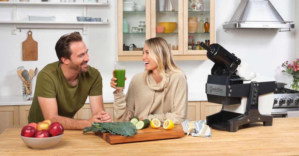 woman and a man making juice at home in the kitchen with a Goodnature cold press juicer