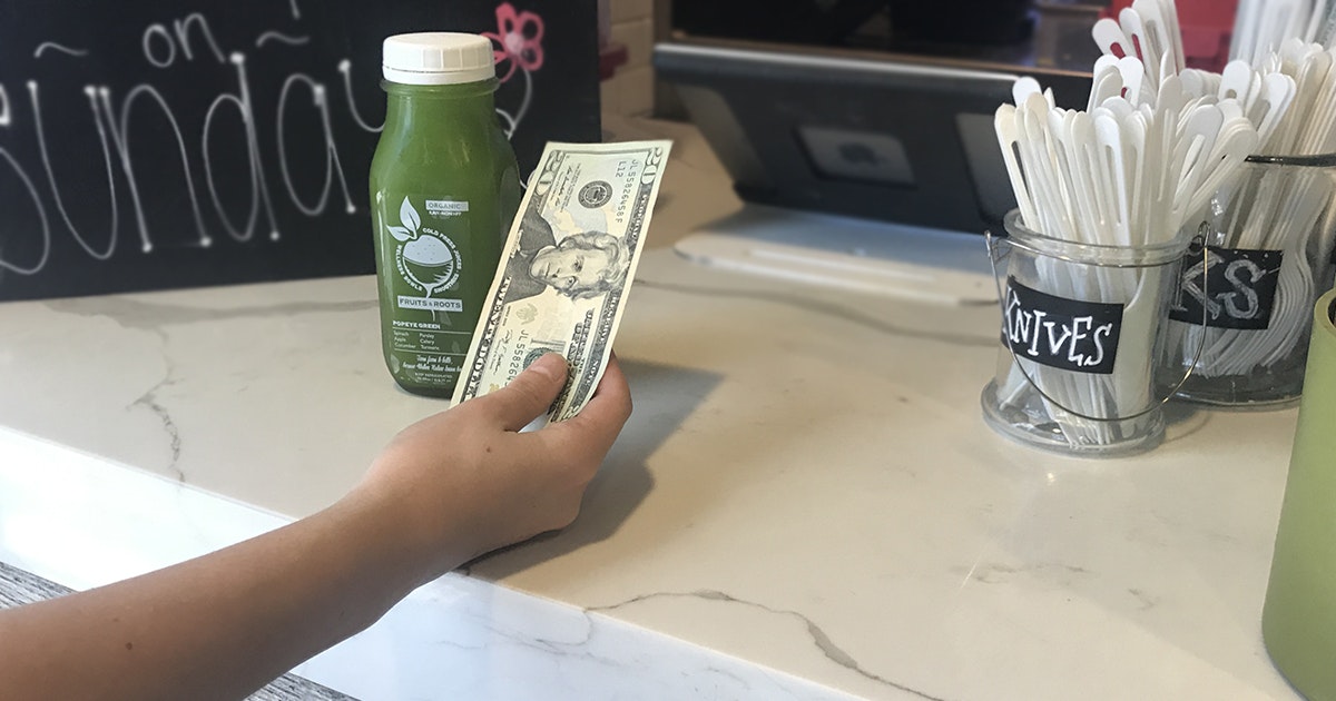 woman paying for juice at a juice bar