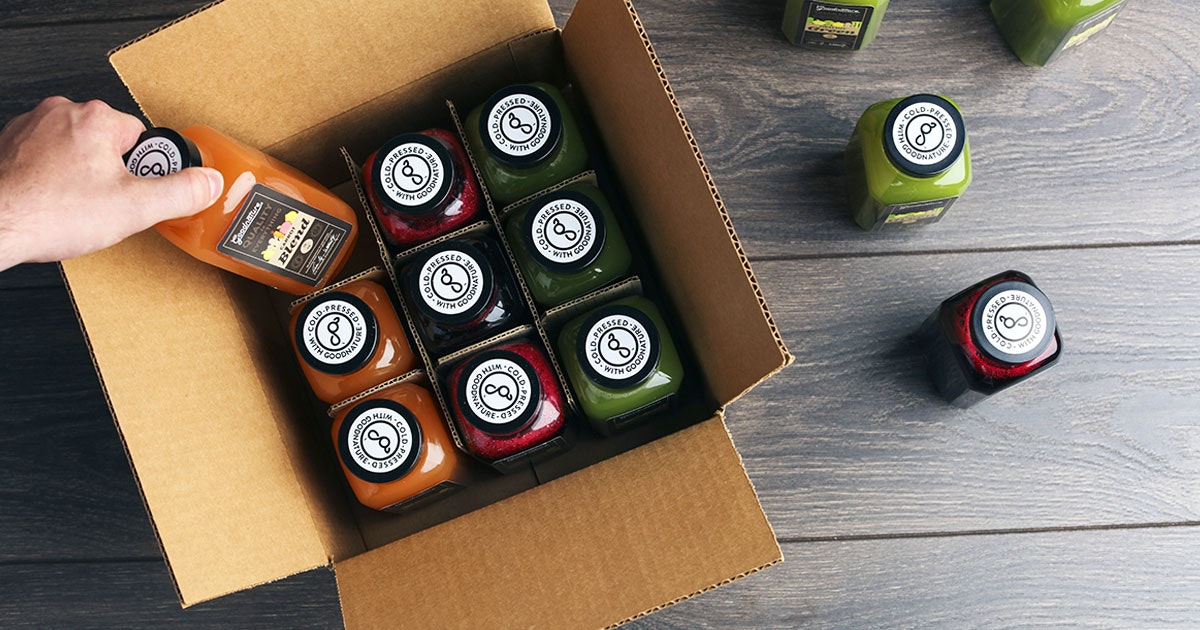 bottles of juice being packed into a cardboard box