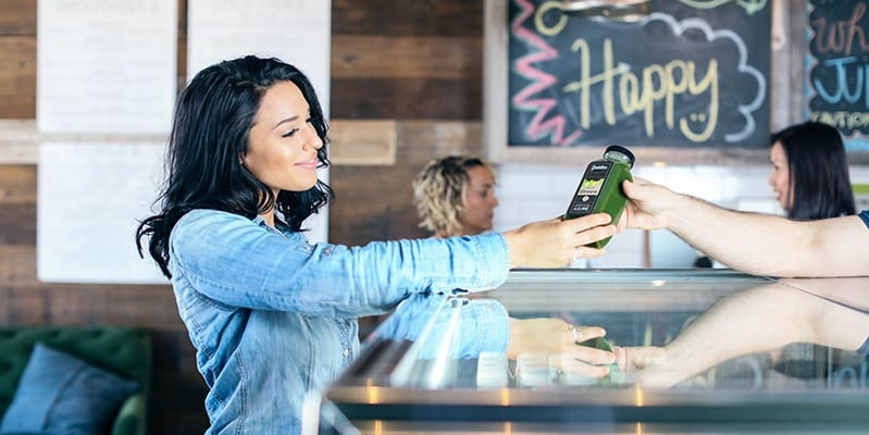 girl being handed a fresh green juice at a juice bar