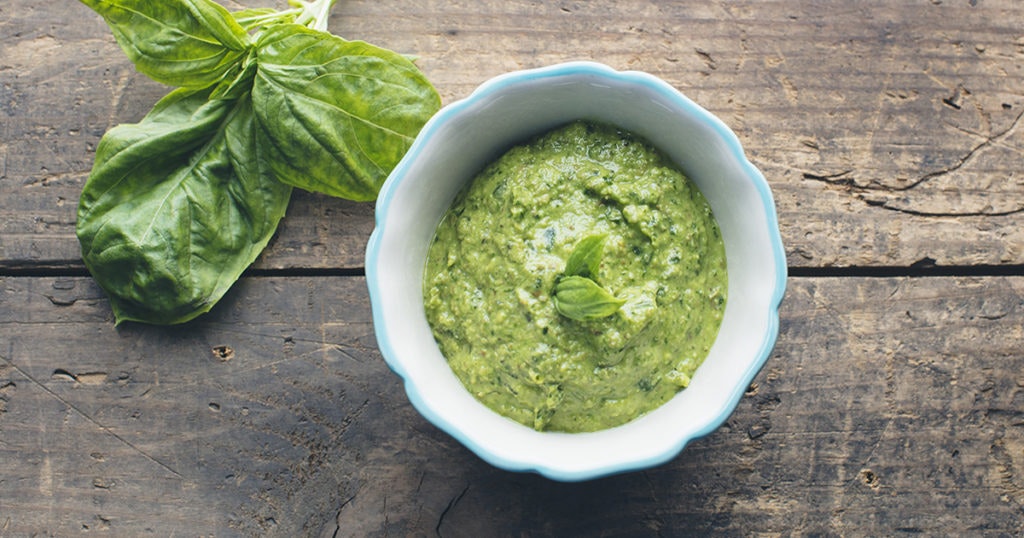 ramekin filled with vegan basil pesto on a wooden table