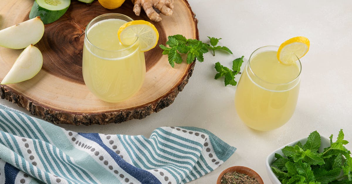 lemon mint juice aka pudina juice on a white table surrounded by ingredients