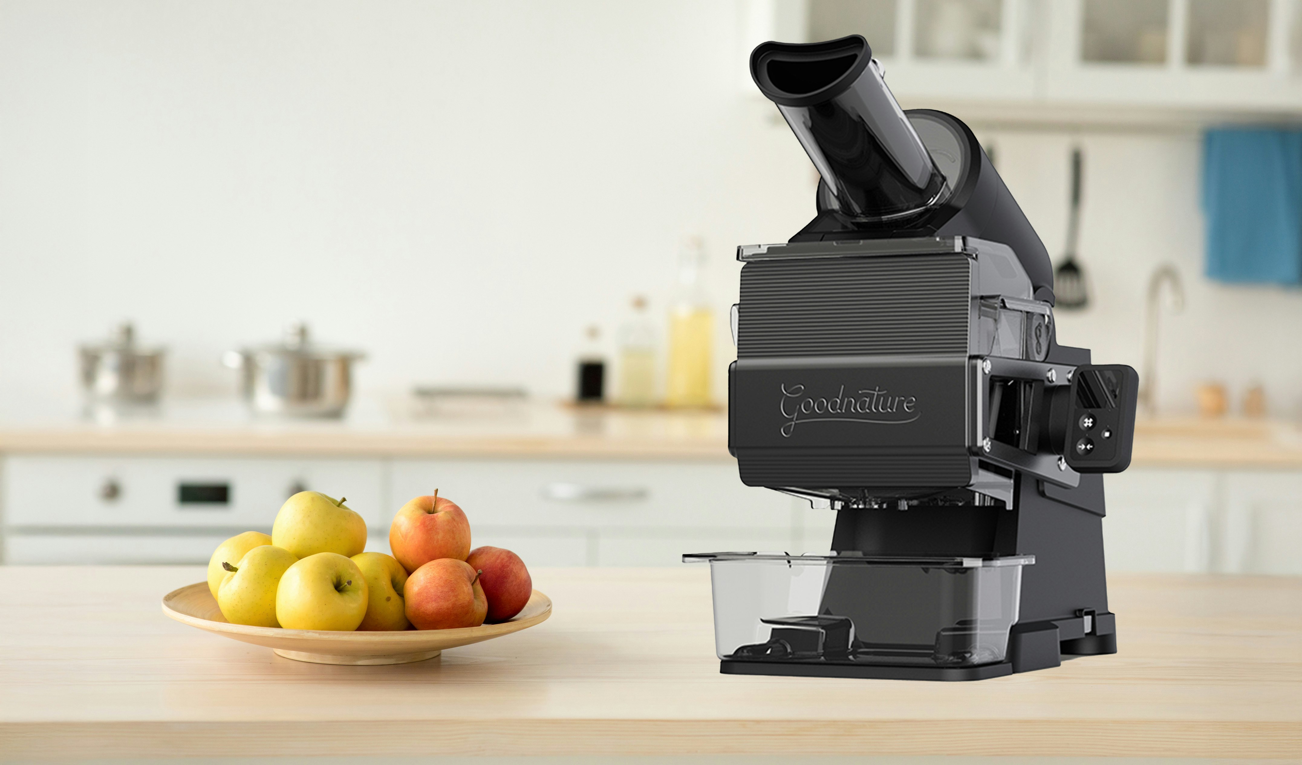 hummingbird juicer on a table with apples