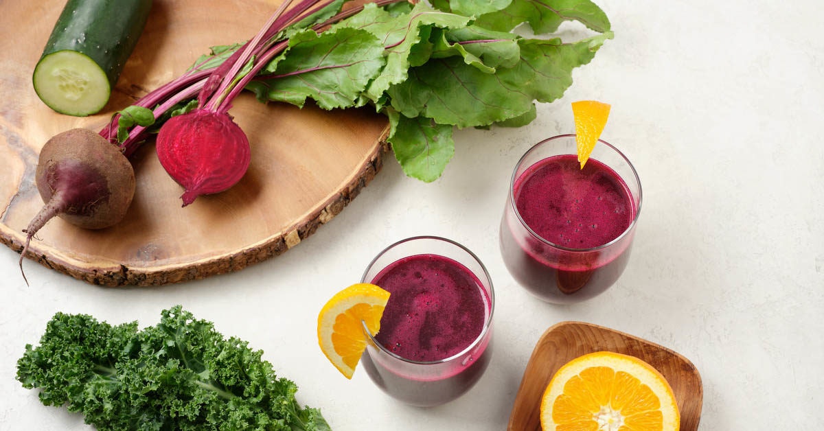 two glasses of beet juice on a white surface