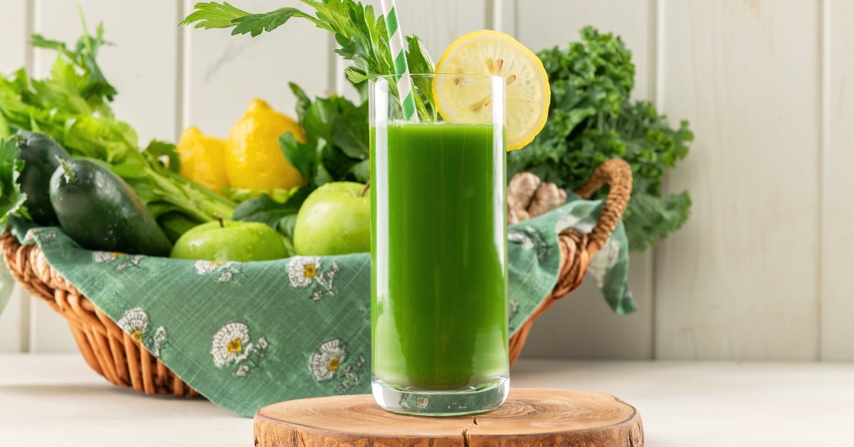 sweet dandelion greens juice recipe on a table next to a basket of ingredients
