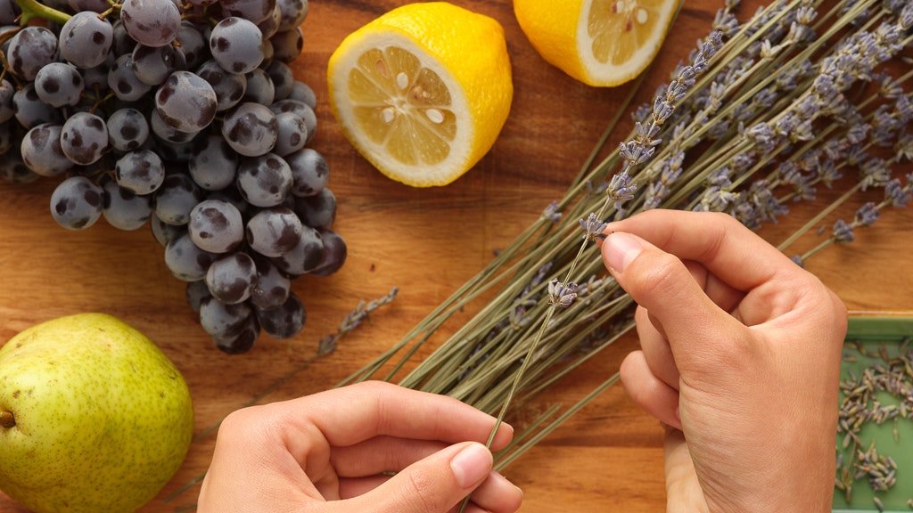 Hands holding herbs with grapes and lemons