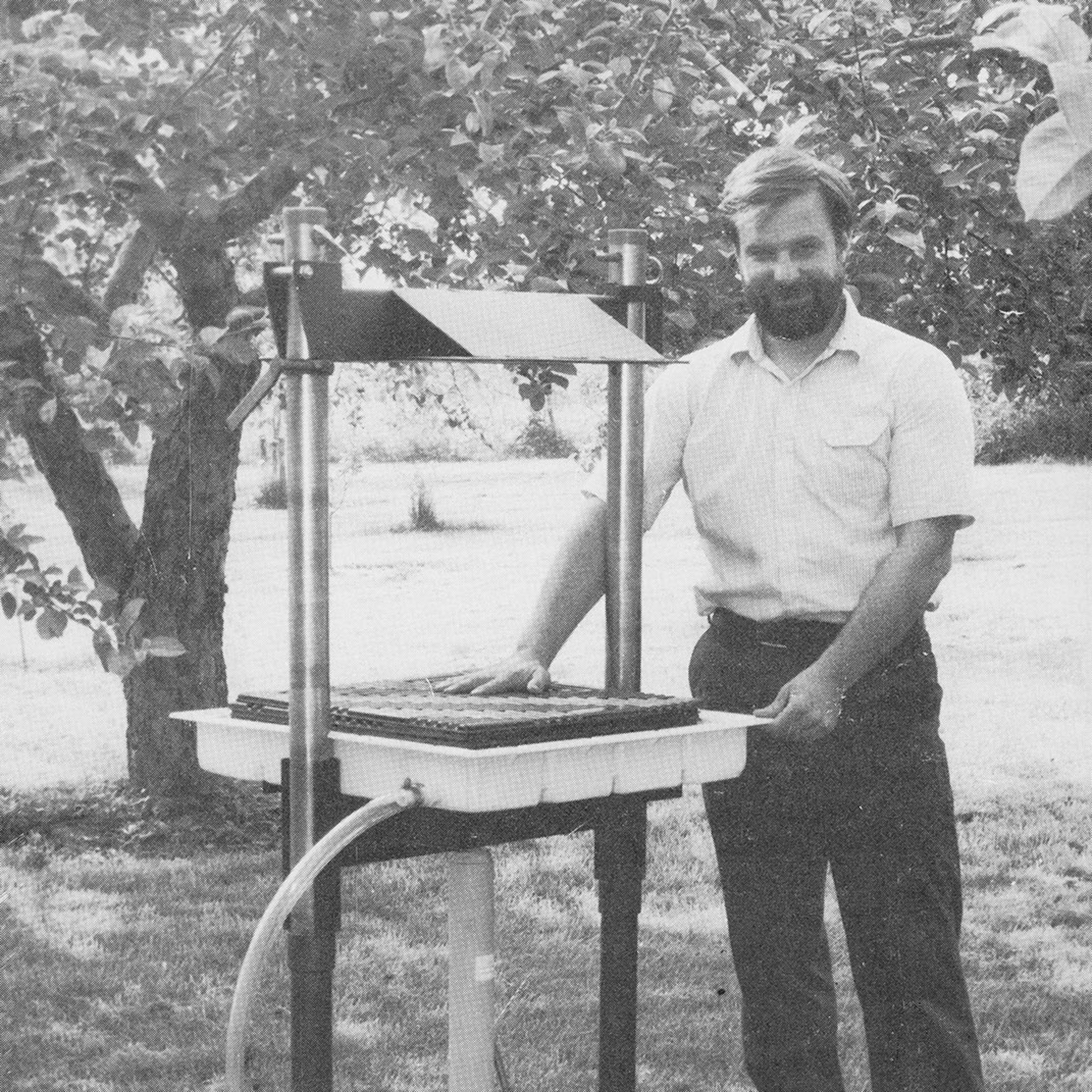 Goodnature founder Dale Wettlaufer standing next to hydraulic cider press