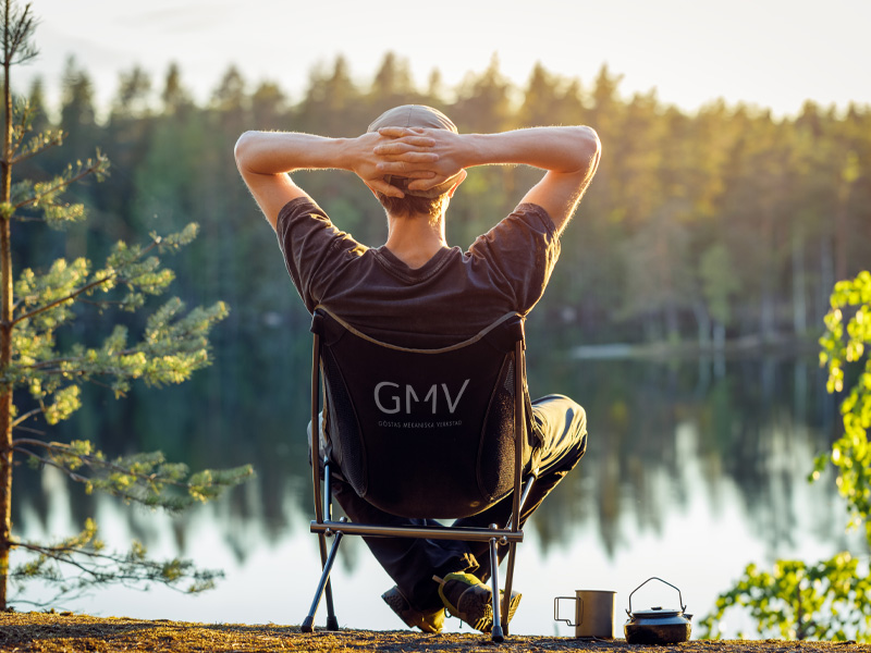 Miljöpolicy | GMV, visar en man i solstol framför en sjö en härlig sommarkväll