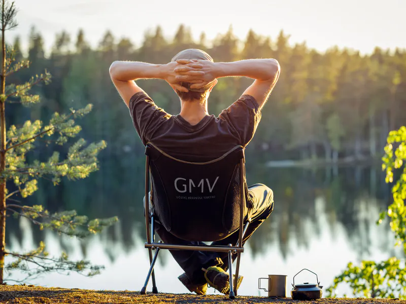 Miljöpolicy | GMV, visar en man i solstol framför en sjö en härlig sommarkväll