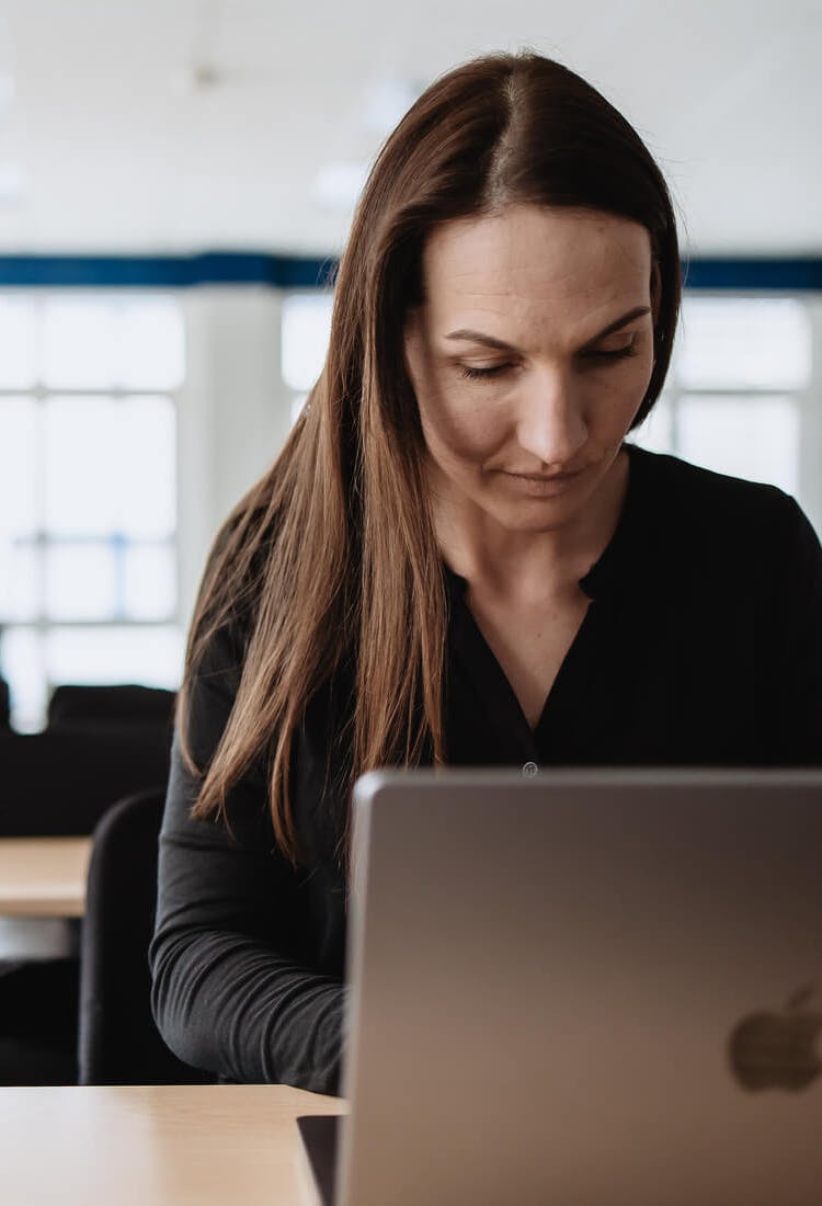Frau ist in ihr MacBook vertieft und arbeitet