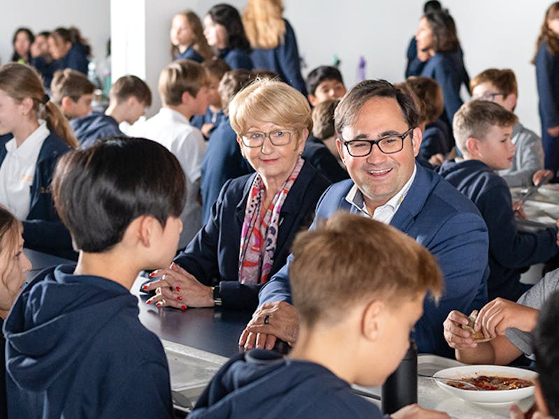 accadis Bildung Vorstand umgeben von Kindern