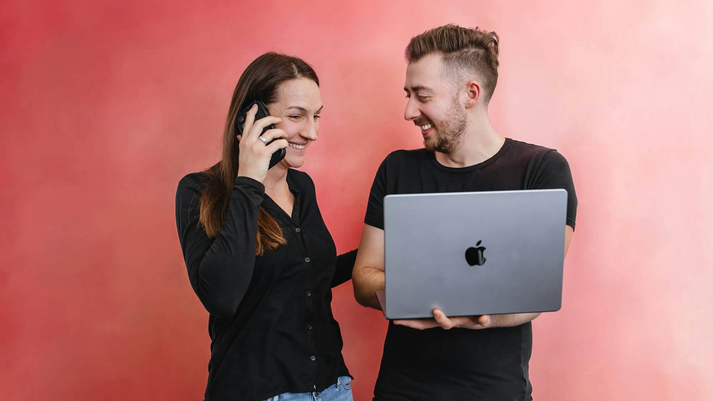Zwei Berufswechsel unterhalten sich über ihren Quereinstieg in die IT vor einem Laptop.
