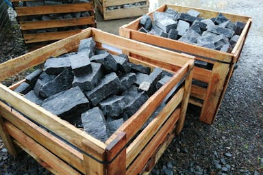 Half tonne crates of black naturally split granite setts