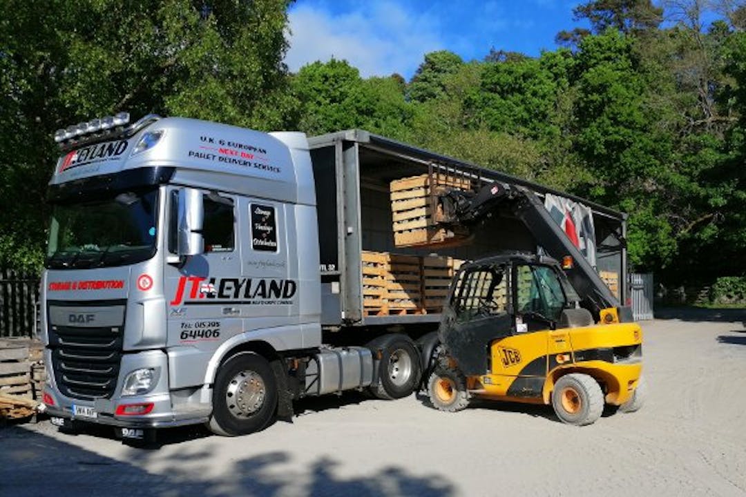 A lorry being loaded with 1-tonne crates of granite setts