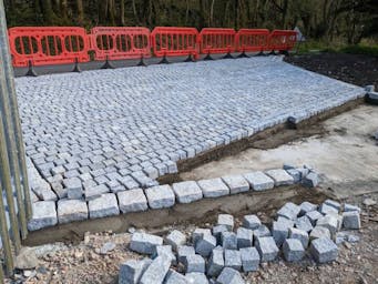 Driveway entrance edged with oversized granite setts