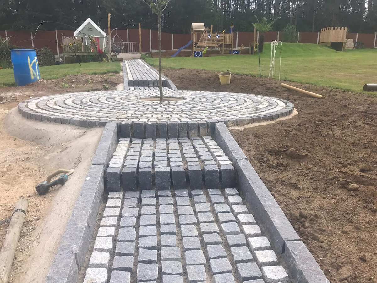 A granite sett pathway towards to end of its construction