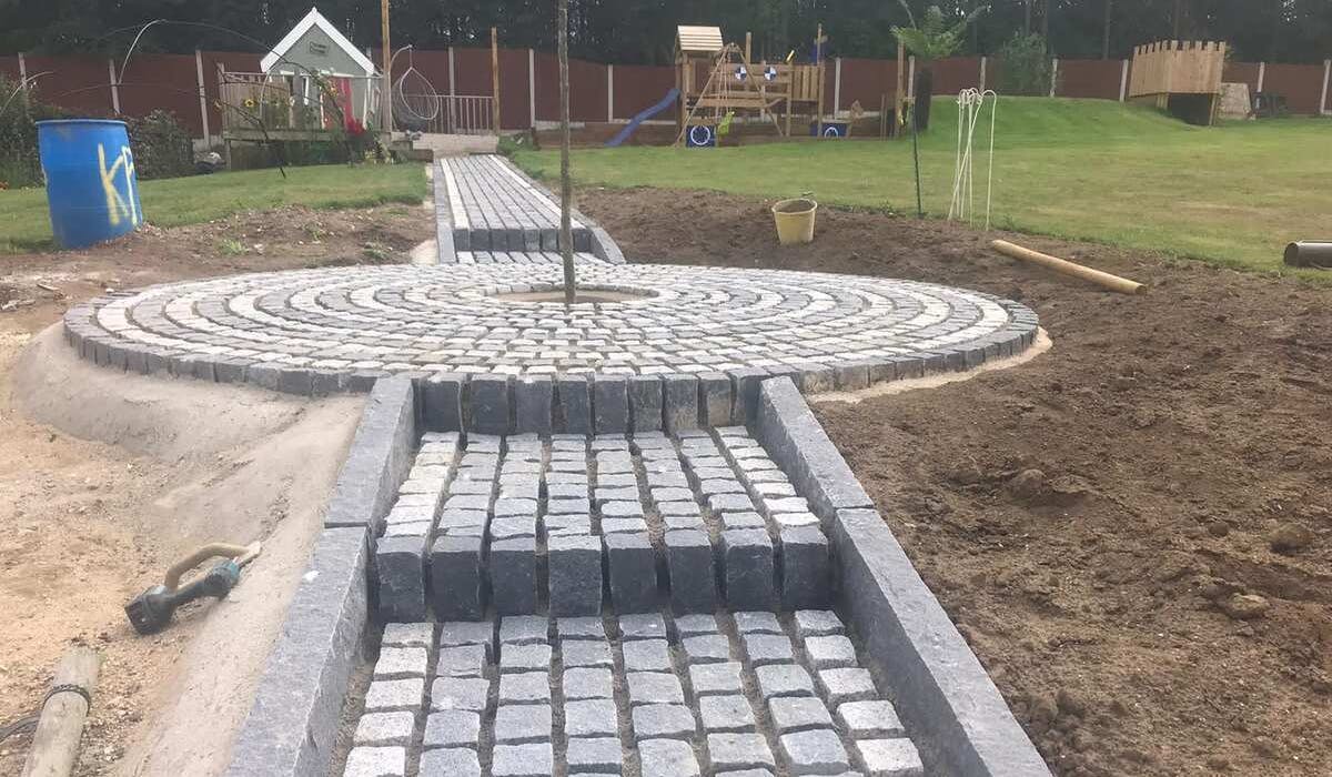 A granite sett pathway towards to end of its construction