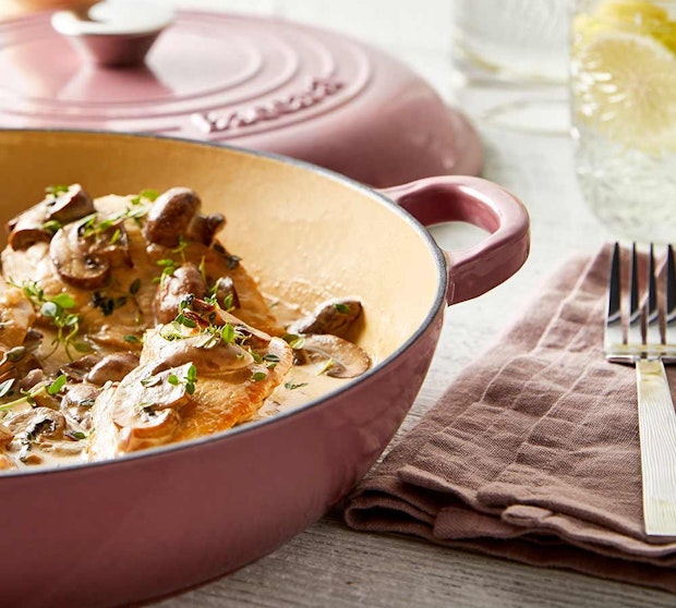 Baccarat Le Connoisseur Dutch Ovens, Saute pans and Baking Dishes. Saute pan with pasta dish resting on a pink tea towel.
