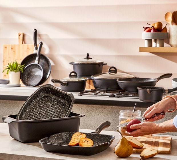 Alt text: Baccarat Cookware sets. Baccarat STONE 10 Piece cookware set. Woman in the kitchen preparing fruit in a grill pan