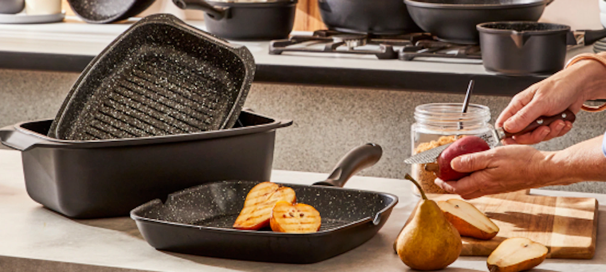 10pc cookware set on the bench with a person cutting fruit