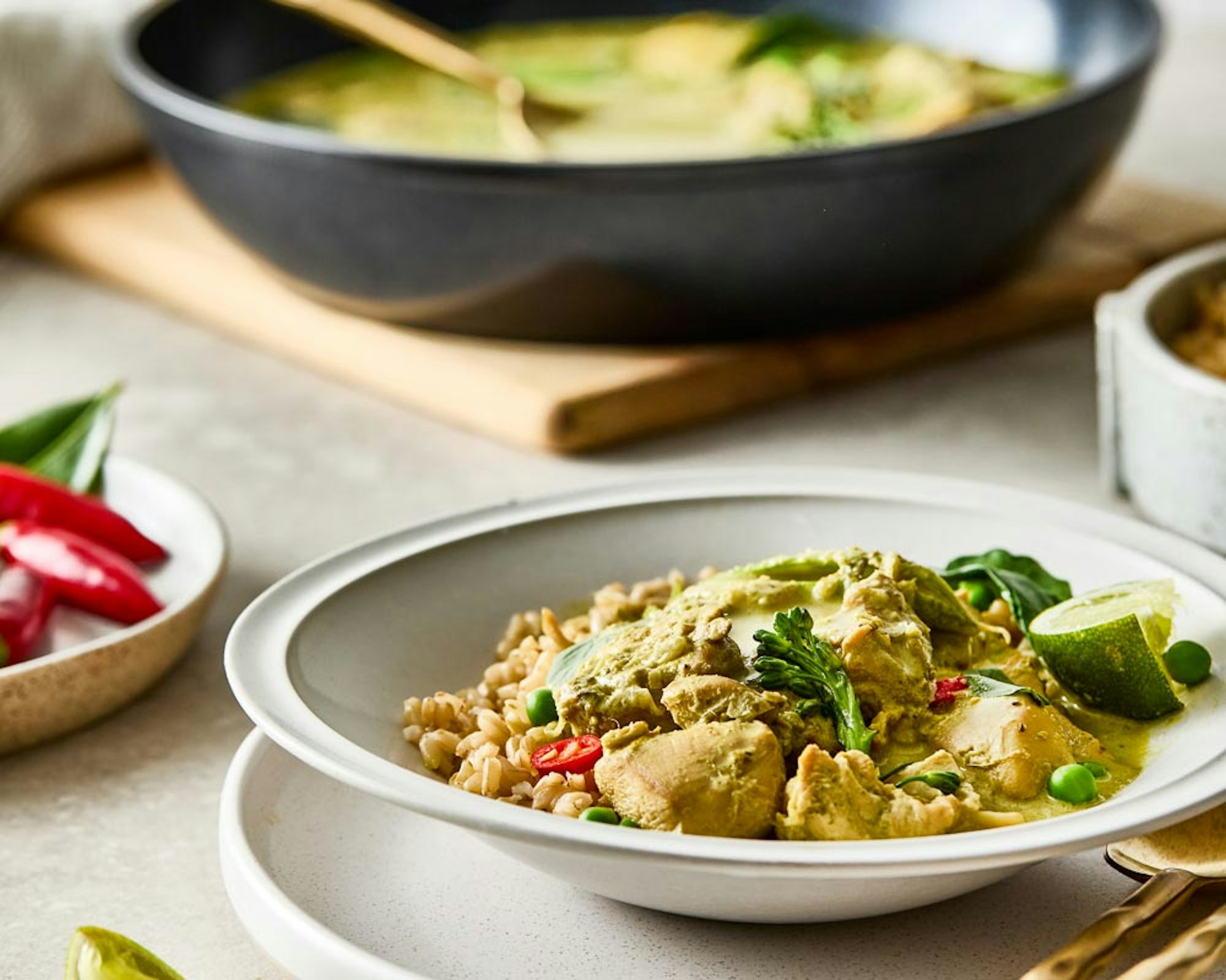 Bowl of curry on table with frypan filled with curry - Baccarat Thai Green Chicken Curry recipe