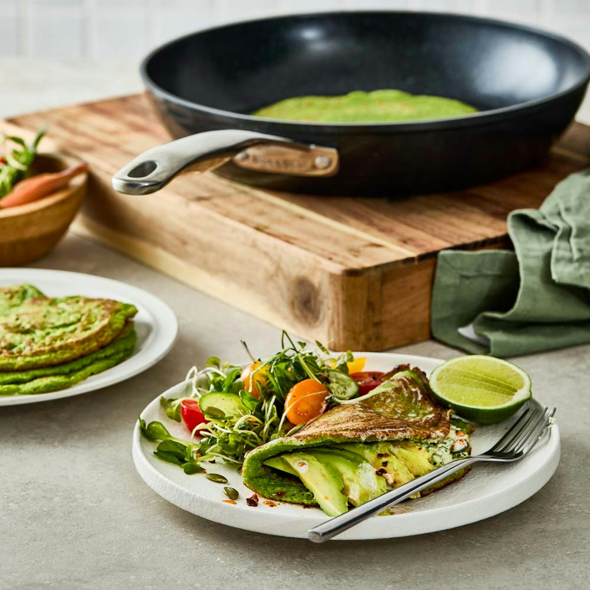 Serving of Super greens pancakes with salad next to Baccarat Green Stone frypan. Baccarat Super Greens Recipe.