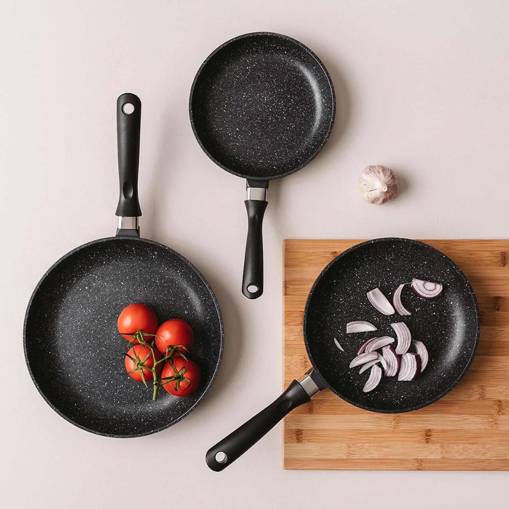 STONE Non Stick Frypan Tri Pack 20cm, 24cm & 28cm on benchtop with cutting board