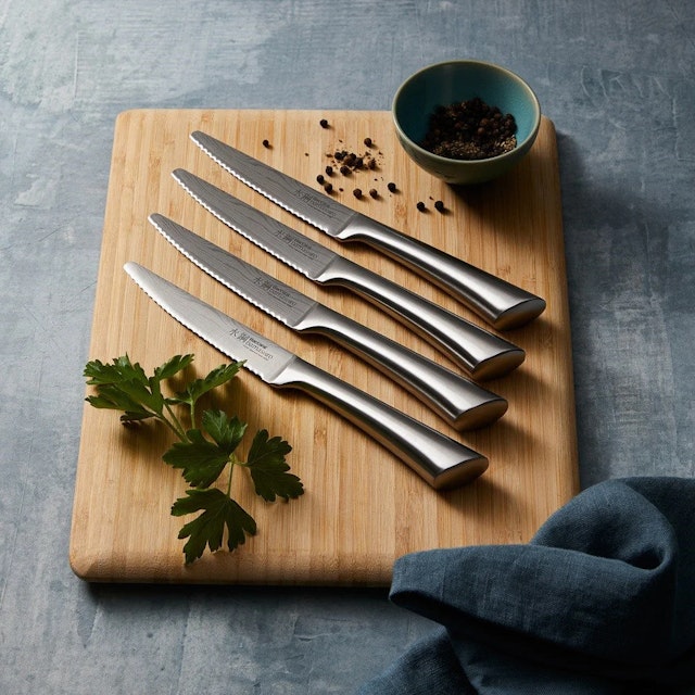 Baccarat Damashiro 4 Piece Steak Knife Set on a cutting board