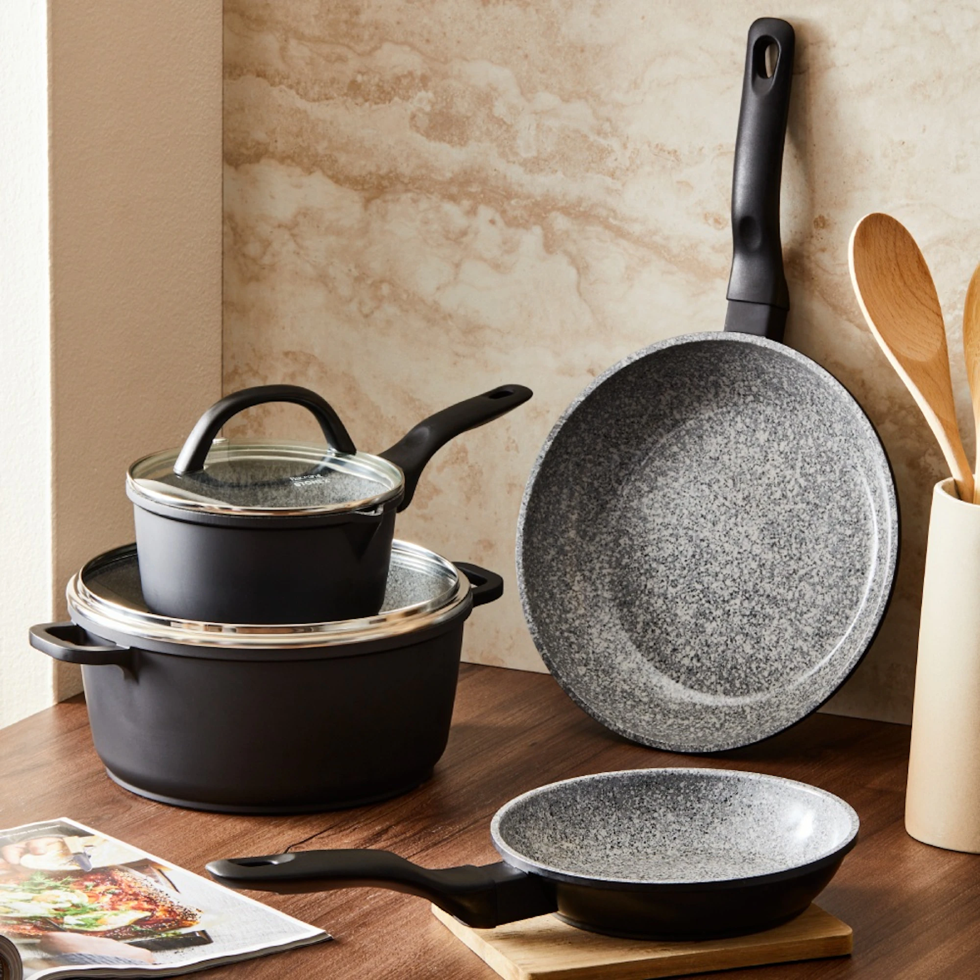 Baccarat grey and black cookware set on table and leaning against a wall
