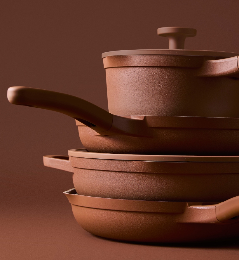 NOOK Terracotta cookware collection stacked on a terracotta background