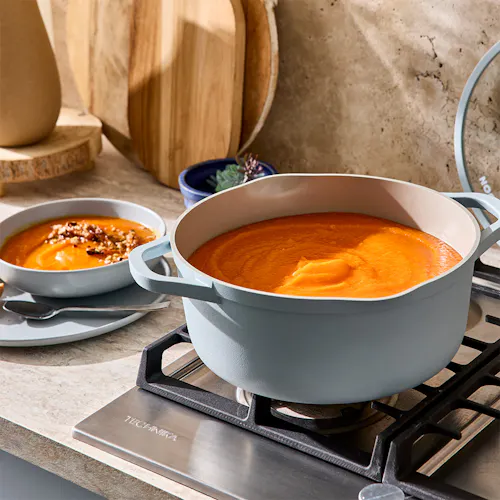 Nook Sky Casserole on a stove cooking pumpkin soup with a matching blue bowl