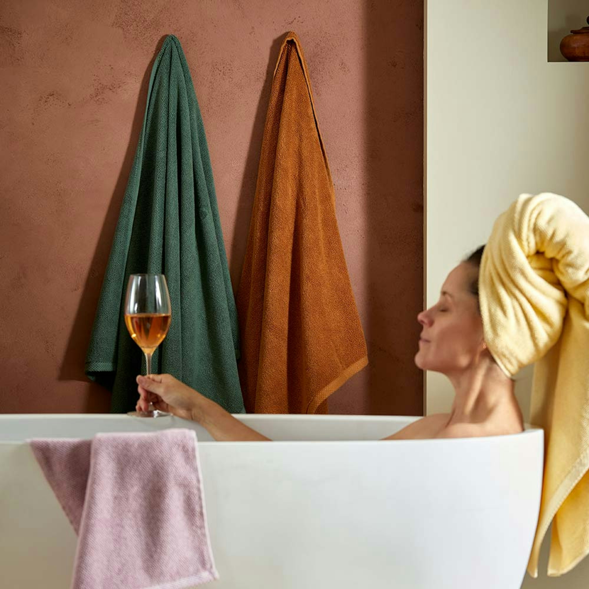 MyHouse Oslo Towel collection. Mother's day gift guide. Woman sitting in the bath with a glass of wine.